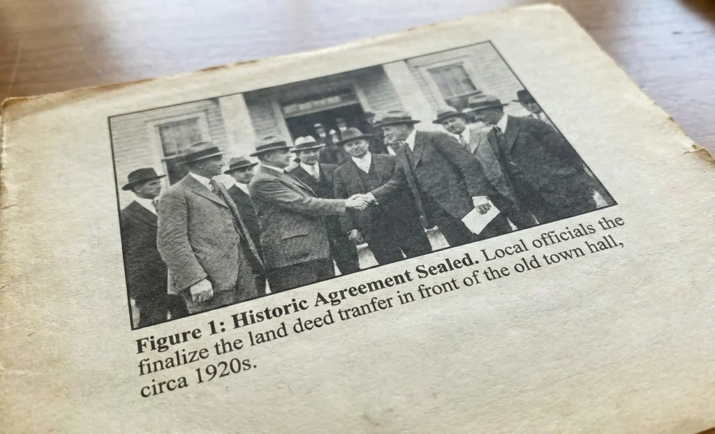 An old photograph of the signing of an agreement and its caption.